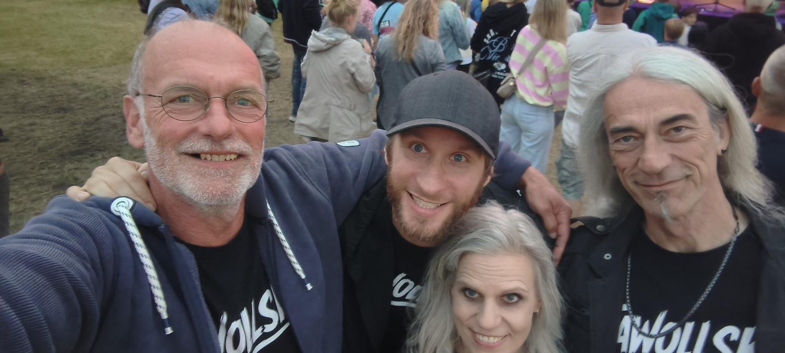 Die vier Bandmitglieder von Jawollski! zusammen auf einem Festival, alle in Band-Shirts