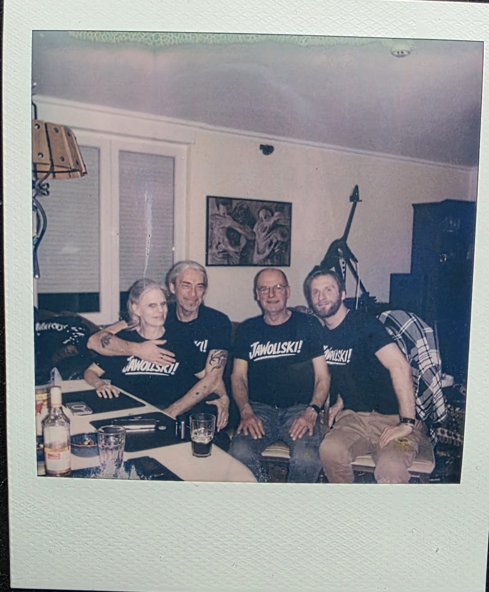 Die vier Bandmitglieder von Jawollski! gemeinsam auf dem Sofa, in Band-Shirts